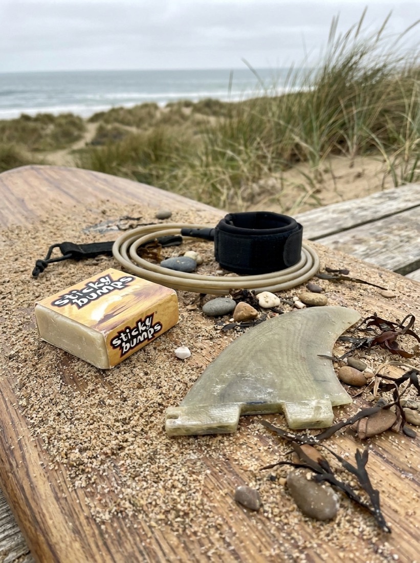 Close-up of surf wax and bright fins laid out on a board